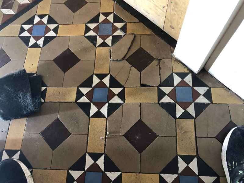 Loose and uneven Edwardian clay floor tiles before restoration in Burton upon Trent hallway
