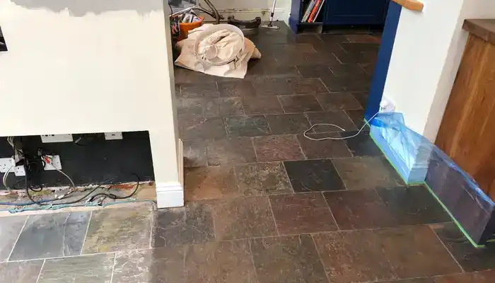 Slate floor with darker walkway areas and uneven colour across the tiles