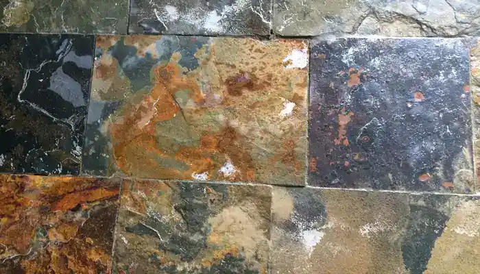 Worn slate floor with damaged grout lines and areas needing repair